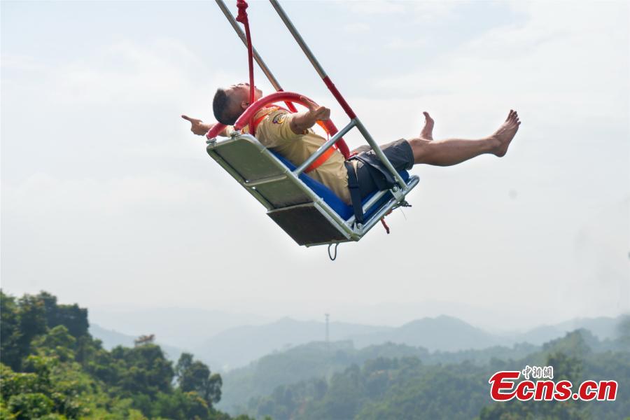 Photo shows a tourist experiencing the cliff swing that officially opened to the public in Qingyuan, Guangdong Province on December 19, 2018. The swing above a 198-meter waterfall on Mount Tianzi in Qingyuan, South China\'s Guangdong Province officially opens on Thursday after a four-month trial operation.  (Photo: China News Service/Cheng Jingwei)