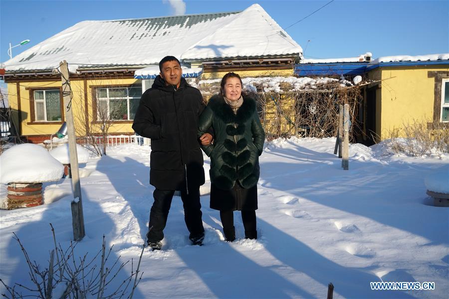 A couple who run accommodation business pose for photo in their yard in Burqin County, northwest China\'s Xinjiang Uygur Autonomous Region, Dec. 22, 2018. Burqin County, home to the region\'s renowned Kanas Lake, which takes tourism as its pillar industry speeds up the development of local tourism from single scenic spot to holiday resort in recent years. (Xinhua/Han Yuqing)