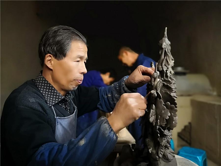 Liu Quan carves a phoenix, a bird from traditional Chinese myths. (Photo by Wei Jianjun for chinadaily.com.cn)