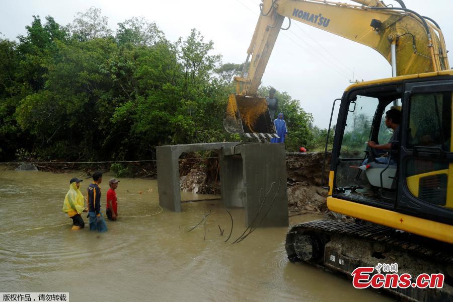 Workers install an emergency bridge over a river, next to a beach hit by tsunami, near Sumur, Banten province, Indonesia, Dec. 26, 2018. Indonesian rescue teams on Wednesday struggle\