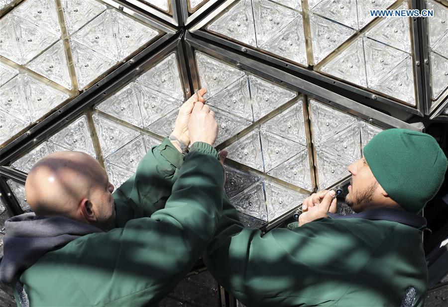 Workers install a panel with new crystal triangles onto the New Year\'s Eve Ball during a ceremony on the roof of the One Times Square building in New York City, the United States, on Dec. 27, 2018. The iconic New Year\'s Eve Ball at New York City\'s Times Square had its latest decoration done on Thursday for the upcoming celebrations. For Times Square 2019, 192 Waterford Crystal triangles introduce the new Gift of Harmony design of small rosette cuts flowing into each other in beautiful harmony. Covered with a total of 2,688 Waterford Crystal triangles, the ball is 12 feet (3.66 meters) in diameter and weighs 11,875 pounds (5386.4 kilograms). (Xinhua/Wang Ying)