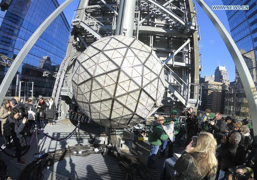 Workers show a panel with new crystal triangles during a ceremony on the roof of the One Times Square building in New York City, the United States, on Dec. 27, 2018. The iconic New Year\'s Eve Ball at New York City\'s Times Square had its latest decoration done on Thursday for the upcoming celebrations. For Times Square 2019, 192 Waterford Crystal triangles introduce the new Gift of Harmony design of small rosette cuts flowing into each other in beautiful harmony. Covered with a total of 2,688 Waterford Crystal triangles, the ball is 12 feet (3.66 meters) in diameter and weighs 11,875 pounds (5386.4 kilograms). (Xinhua/Zhang Mocheng)