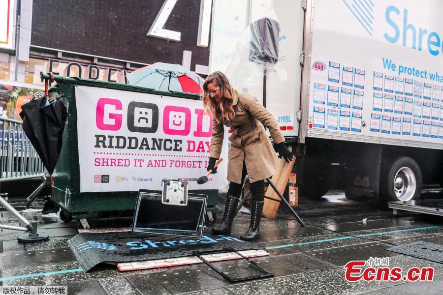 Allison Hagendorf mashes computer parts with a hammer during the National Good Riddance day ceremonial shredding of bad memories of 2018 in Times Square in the Manhattan borough of New York, U.S., Dec. 28, 2018.  (Photo/Agencies)
