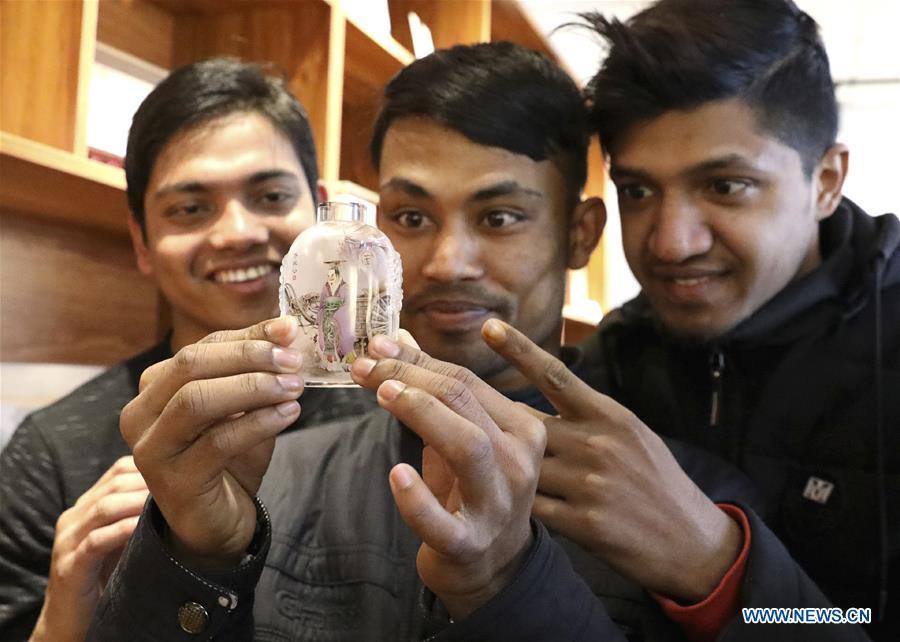 International students from Bangladesh observe an inner painted snuff bottle at Hebei College of Industry and Technology in Shijiazhuang, north China\'s Hebei Province, Dec. 28, 2018. The college takes intangible cultural heritages such as techniques of pyrograph and inner painting into school courses in recent years. (Xinhua/Liang Zidong)
