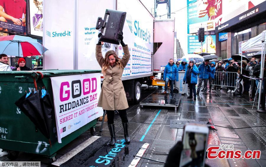 Allison Hagendorf mashes computer parts with a hammer during the National Good Riddance day ceremonial shredding of bad memories of 2018 in Times Square in the Manhattan borough of New York, U.S., Dec. 28, 2018.  (Photo/Agencies)