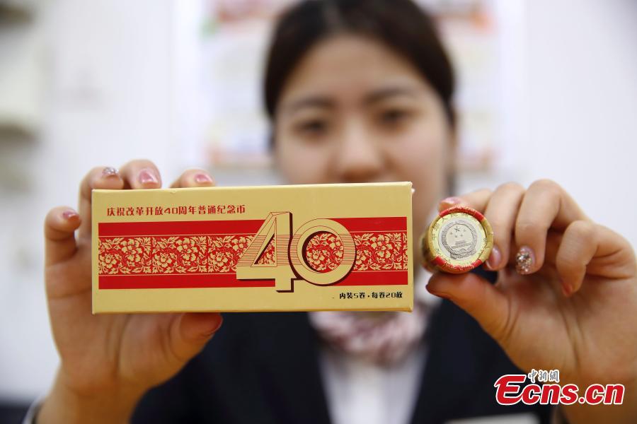 Photo taken on Dec. 28, 2018 shows banknotes and coins to commemorate the 70th anniversary of the establishment of the People\'s Bank of China and the 40th anniversary of the reform and opening-up respectively go on sale in Taiyuan City, North China\'s Shanxi Province. The 50-yuan commemorative banknote is 150 millimeters long and 70 millimeters wide, the same size as the regular 50-yuan banknote in the country\'s fifth set of notes. (Photo: China News Service/Zhang Yun)