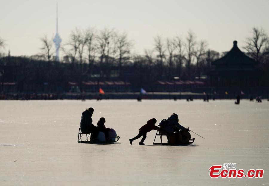 People have fun on the frozen Kunming Lake at the Summer Palace in Beijing, Dec. 30, 2018. With an area of 700,000 square meters, Kunming Lake is the largest natural ice rink in winter in Beijing.The ice rink was open to the public on Sunday. (Photo: China News Service/Du Yang)