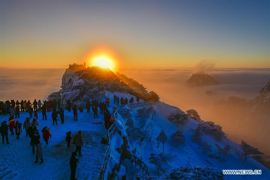 Visitors watch sunrise and clouds on the Huangshan Mountain in east China\'s Anhui Province, Dec. 31, 2018. (Xinhua/Shui Congze)
