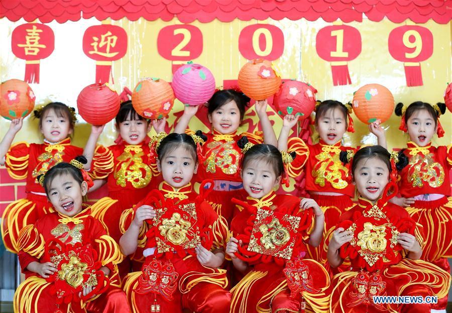 Pupils dressed in festive costumes pose for a group photo in Qingdao, east China\'s Shandong Province, Jan. 1, 2019. (Xinhua/Liang Xiaopeng)