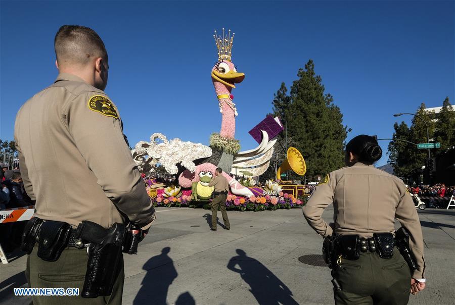Police officers stand guard as a float moves along Colorado Boulevard during the 130th Rose Parade in Pasadena, California, the United States, on Jan. 1, 2019. (Xinhua/Zhao Hanrong)