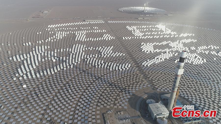Mirrors are arranged to form New Year greetings in Chinese at a 100-megawatt molten-salt solar thermal power plant in Dunhuang City, Northwest China’s Gansu Province, Jan. 1, 2019. The plant is powered by 12,000 mirrors that concentrate sunlight onto a receiver at the top of a solar tower, 260 meters high. The heat collected is used to create steam that turns a turbine and generator, as at a traditional thermal power plant. The molten salt can also be stored and used to generate power on demand, even at night. (Photo: China News Service/Zhou Binquan)