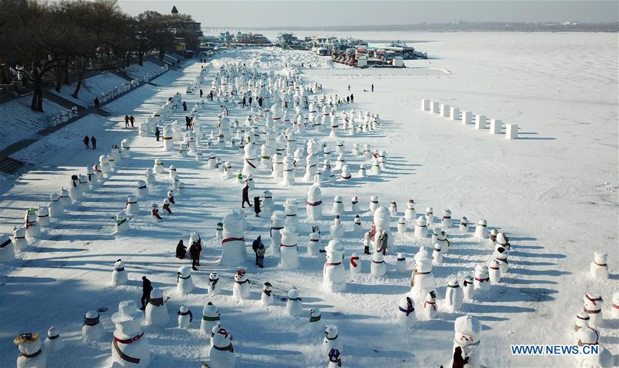 Aerial photo taken on Jan. 2, 2019 shows people viewing snowman sculptures on the riverbank of Songhua River in Harbin, capital of northeast China\'s Heilongjiang Province. Altogether 2,019 cute snowmen were displayed here to greet the year 2019. (Xinhua/Wang Jianwei)