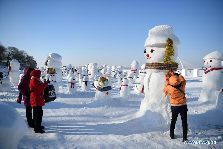 People view snowman sculptures on the riverbank of Songhua River in Harbin, capital of northeast China\'s Heilongjiang Province, Jan. 2, 2019. Altogether 2,019 cute snowmen were displayed here to greet the year 2019. (Xinhua/Wang Jianwei)