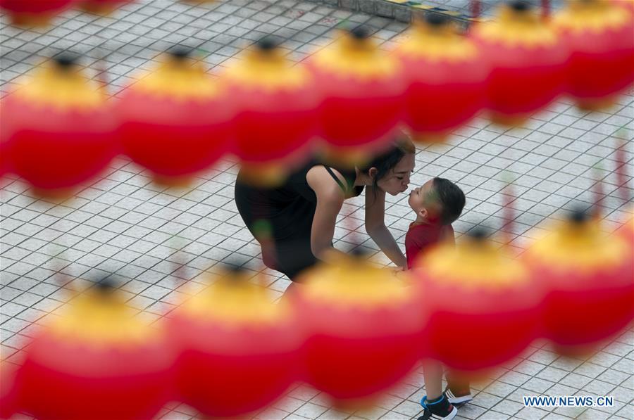 A woman interacts with her child as lanterns are prepared in celebration of the upcoming Chinese lunar New Year in Thean Hou Temple in Kuala Lumpur, Malaysia, Jan. 3, 2019. (Xinhua/Chong Voon Chung)