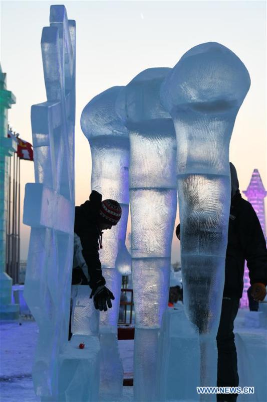 Contestants carve an ice sculpture during an international ice sculpture competition in Harbin, capital of northeast China\'s Heilongjiang Province, Jan. 3, 2019. (Xinhua/Wang Song)
