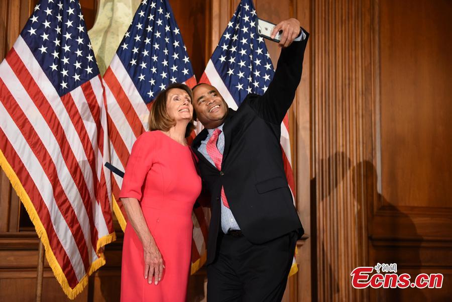 A member of the House of Representatives poses with Speaker of the House Nancy Pelosi (D-Calif.) during the opening session of the 116th Congress in Washington, U.S., January 3, 2019.(Photo: China News Service/Chen Mengtong)