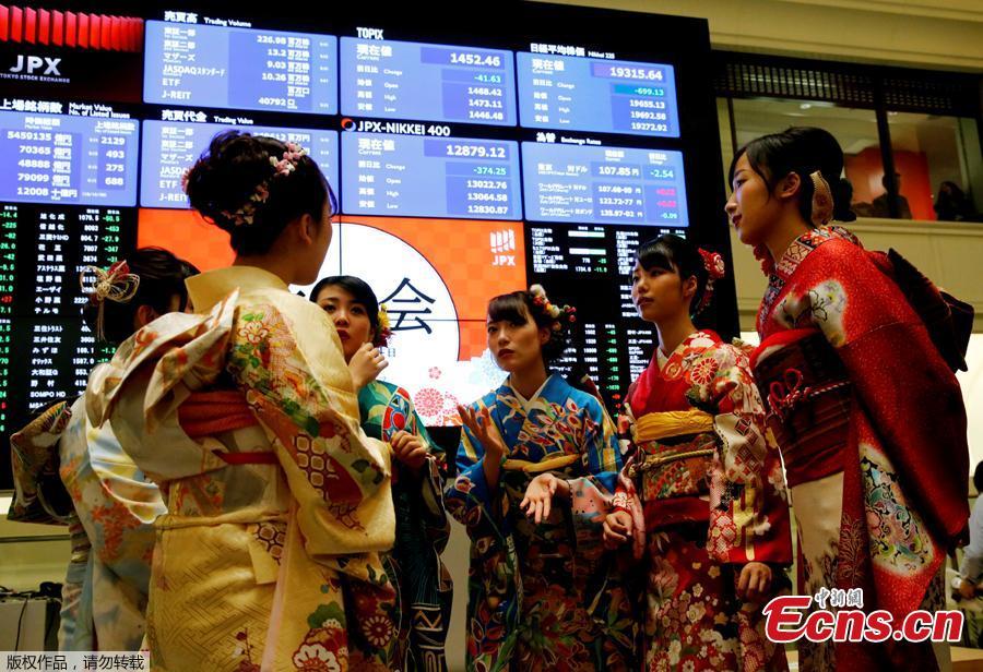 Women, dressed in ceremonial kimonos, pose in front of an electronic board showing stock prices after the New Year opening ceremony at the Tokyo Stock Exchange (TSE), held to wish for the success of Japan\'s stock market, in Tokyo, Japan, January 4, 2019. (Photo/Agencies)