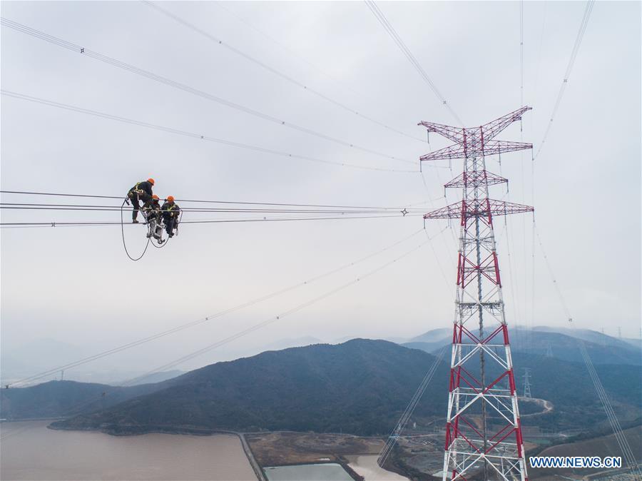 Staff members work on the cables at the site of the giant power supply pylons in Zhoushan, east China\'s Zhejiang Province, Jan. 3, 2019. The two 380-meter-tall pylons carry power cables between Zhoushan\'s Jintang and Cezi islands, a distance of 2,656 meters. The new pylon project is a part of a new ultra-high voltage power line project between cities of Zhoushan and Ningbo. (Xinhua/Xu Yu)