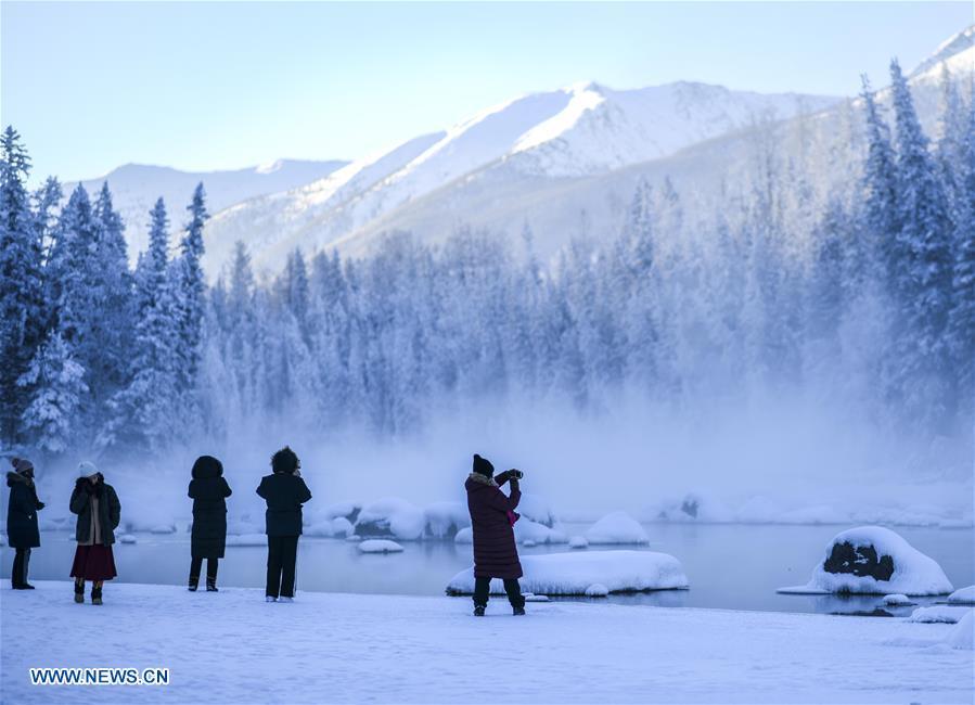 People take photos of scenery near the Kanas Lake in Kanas, northwest China\'s Xinjiang Uygur Autonomous Region, Jan. 2, 2019. Kanas scenic spot attracts lots of visitors in winter with its pure snow scenery and various entertainment. (Xinhua/Zhao Ge)