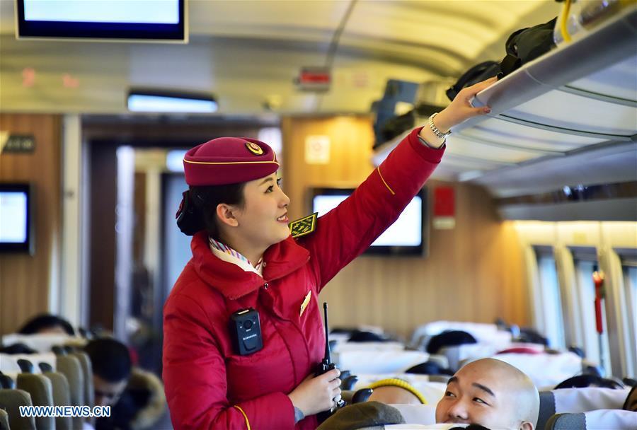 A staff member arranges luggage on a Fuxing high-speed train on the Beijing-Tianjin railway, Jan. 4, 2019. China will put into use the new train diagram starting from Jan. 5.(Xinhua/Yang Baosen)