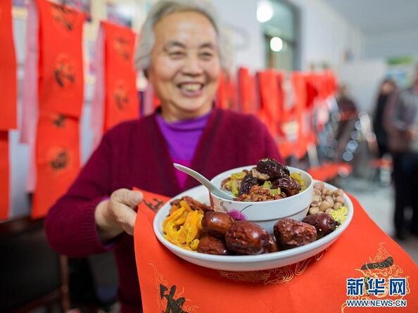 An old woman presents the ingredients of Laba congee to journalists at the Qingquan community of Yuquan district, in Hohhot, capital city of North China\'s Inner Mongolia autonomous region, on Jan 4. (Photo/Xinhua)

Eating Laba porridge

Another important traditional food for Minor Cold is Laba porridge. It is made from more than 20 kinds of nuts, cereals and dried fruits. Local people in Beijing often cook Laba porridge on the night of the seventh day of the twelfth lunar month. After one night\'s slow simmering, all the ingredients melt into the porridge in the morning of the eighth day, becoming a warm delicacy to enjoy on cold days.