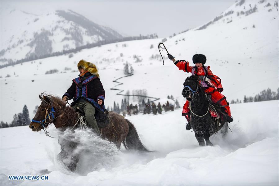 Local residents perform horse chasing in snow in Hom scenic area of Kanas, northwest China\'s Xinjiang Uygur Autonomous Region, Jan. 1, 2019. Kanas scenic spot attracts lots of visitors in winter with its pure snow scenery and various entertainment. (Xinhua/Zhao Ge)