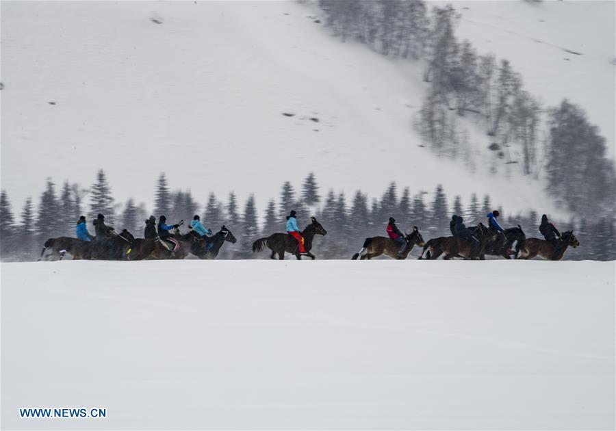 Local residents perform horse riding in snow in Hom scenic area of Kanas, northwest China\'s Xinjiang Uygur Autonomous Region, Jan. 1, 2019. Kanas scenic spot attracts lots of visitors in winter with its pure snow scenery and various entertainment. (Xinhua/Zhao Ge)
