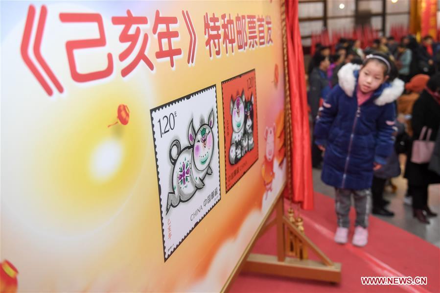 A kid is seen during the issue ceremony of special zodiac stamps for the lunar year of the Pig in Hefei, capital of east China\'s Anhui Province, Jan. 5, 2019. China Post on Saturday issued a set of special zodiac stamps in honor of 2019 Chinese Lunar New Year, or the Year of the Pig. The Year of the Pig starts from Feb. 5, 2019. (Xinhua/Zhang Duan)