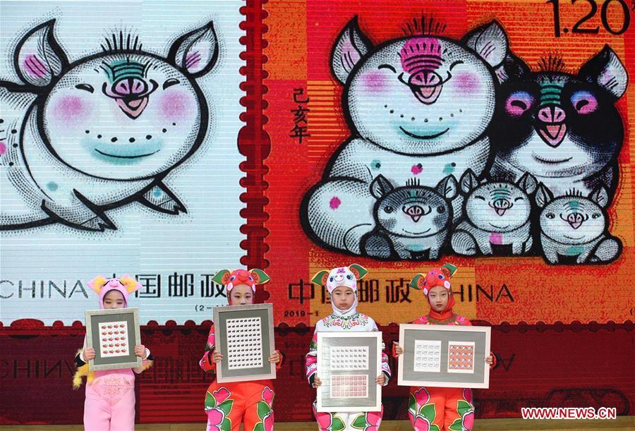 Kids present special zodiac stamps for the lunar year of the Pig in Nanjing, capital of east China\'s Jiangsu Province, Jan. 5, 2019. China Post on Saturday issued a set of special zodiac stamps in honor of 2019 Chinese Lunar New Year, or the Year of the Pig. The Year of the Pig starts from Feb. 5, 2019. (Xinhua/Sun Can)