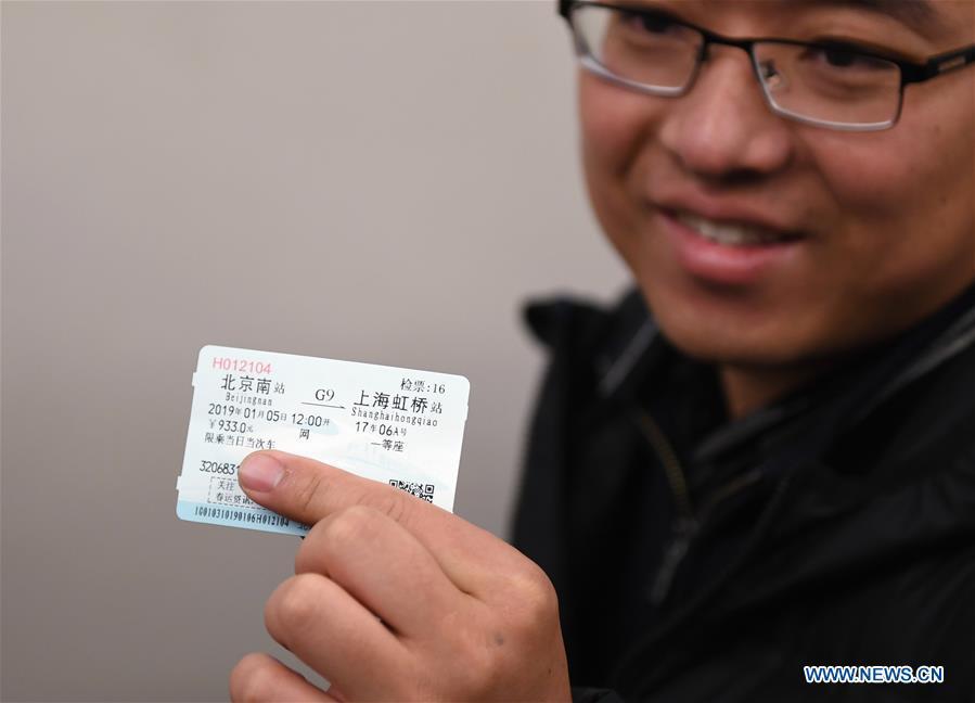 A passenger shows his ticket for a seat in the 17th carriage of a new Fuxing bullet train, at Beijing South Railway Station in Beijing, capital of China, Jan. 5, 2019. A longer Fuxing bullet train started running on the Beijing-Shanghai line Saturday at noon. The new train, with a designed speed of 350 km per hour, has 17 carriages, one carriage longer than the Fuxing trains currently in use. (Xinhua/Zhang Chenlin)