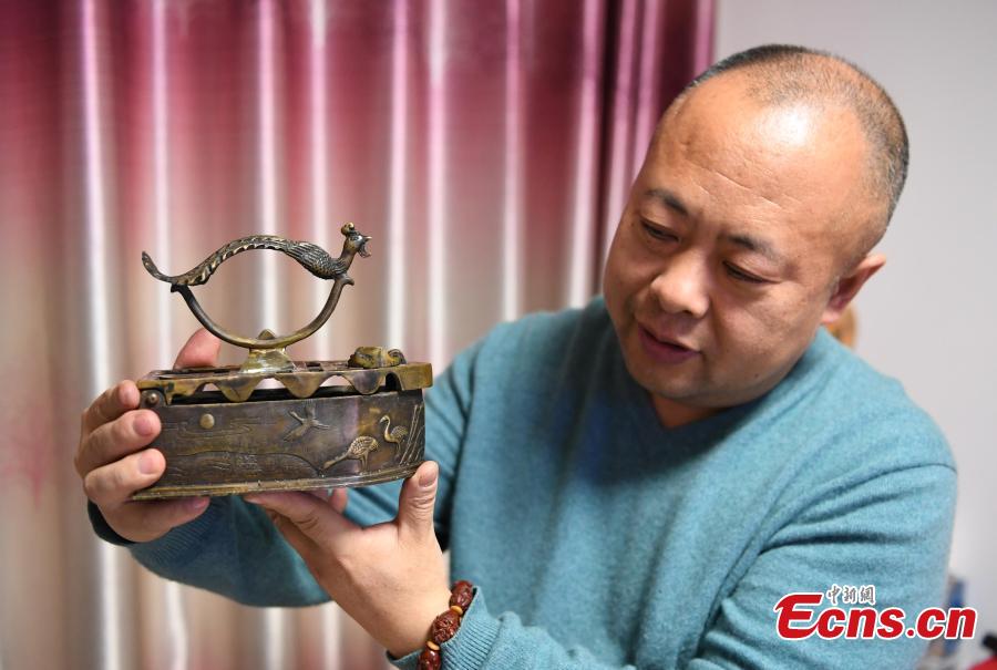 Teng Yongshan of Jilin City in Jilin Province shows his collection of irons - a collection he began in 2000. The former teacher has collected more than 40 irons that were made during the Jin (1115-1234) to Qing Dynasties (1368-1644) and in the early Republic period. Some of the irons were imported into China, including some from Japan and Germany. (Photo: China News Service/Zhang Yao)