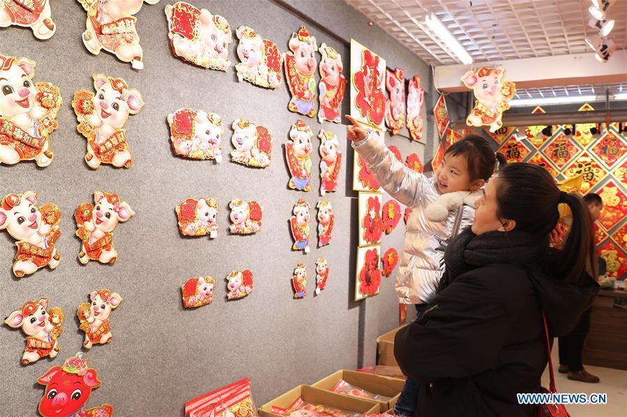 Customers select New Year goods at a market in Shijiazhuang, north China\'s Hebei Province, Jan. 6, 2019. People are busy buying decorations such as Spring Festival couplets and lanterns to greet the upcoming Lunar New Year. (Xinhua/Liang Zidong)