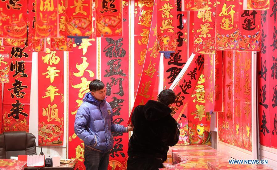 Customers select New Year goods at a market in Shijiazhuang, north China\'s Hebei Province, Jan. 6, 2019. People are busy buying decorations such as Spring Festival couplets and lanterns to greet the upcoming Lunar New Year. (Xinhua/Liang Zidong)