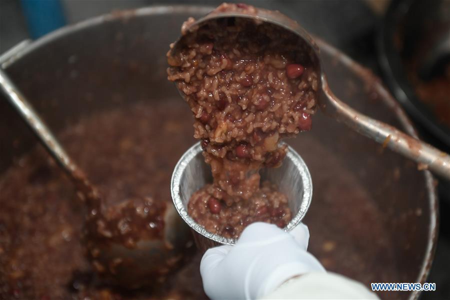 A volunteer packs Laba porridge just cooked at Lingyin Temple in Hangzhou, capital of east China\'s Zhejiang Province, Jan. 6, 2019. Lingyin Temple started to make the traditional Laba porridge on Sunday, which was the first day of the 12th month of the Chinese lunar calendar, and will share it with local community for free. (Xinhua/Huang Zongzhi)