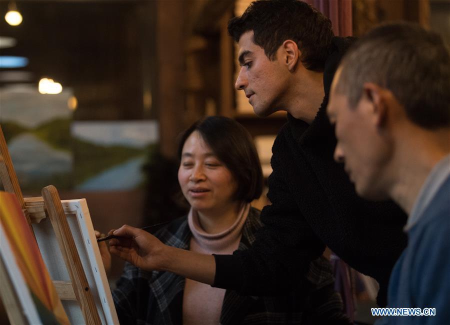 Staff members of a guesthouse learn oil painting under the instruction of Mehraz Karami at his workshop in Shanbei Village of Daixi Town in Huzhou City, east China\'s Zhejiang Province, Jan. 7, 2019. Iranian Mehraz Karami, who was born in Tehran in 1993, has shown his interest in Chinese culture ever since his childhood. He came to Daixi Town and set up his own painting workshop at the end of 2017 after graduation from east China\'s Shanghai. He said he hoped to stay in China and become an artist. (Xinhua/Weng Xinyang)