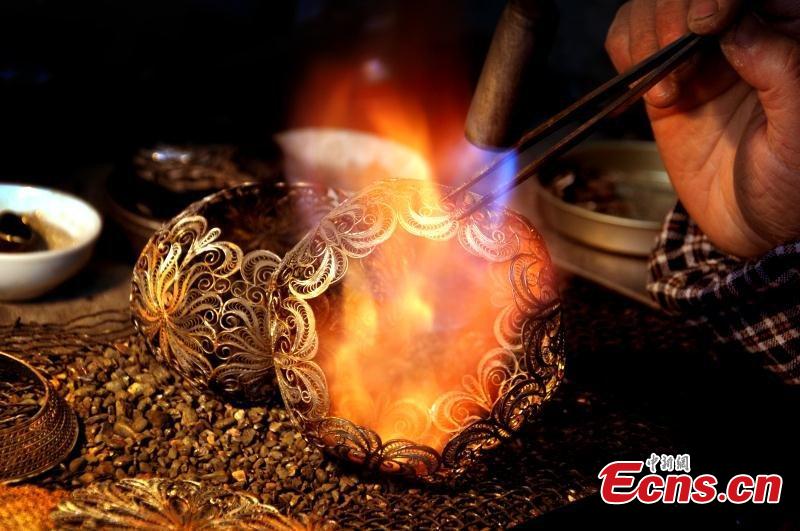 Artisans use silver thread to make crafts in Chengdu City, Southwest China\'s Sichuan Province. The craft dates back to the Song Dynasty (960-1279) and involves time-consuming, elaborate steps to pull a one-meter silver piece into a 1000-meter thin thread, which is then used to make all kinds of handmade works. In 2008, the craft was included as a national intangible cultural heritage. (Photo: China News Service/Zhong Xin)