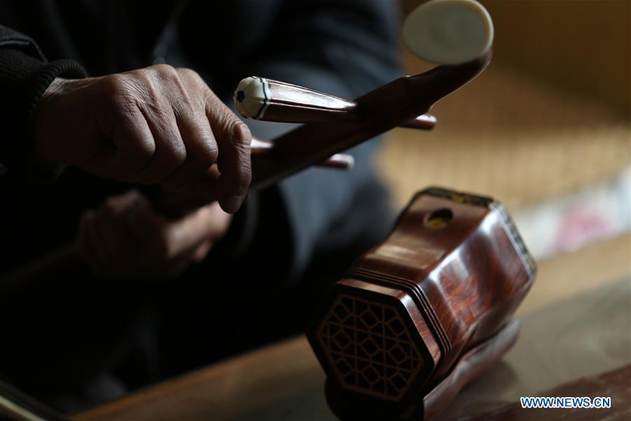 Villager Gao Zhenbao assembles parts of Erhu, a Chinese two-stringed bowed instrument at Yuequan Village of Miaoshan Town in Linyi City, east China\'s Shandong Province, Jan. 8, 2019. Yuequan is famous for its time-honored handmade Erhu, with more than 90 households dedicated to it in the village. (Xinhua/Zhang Chunlei)