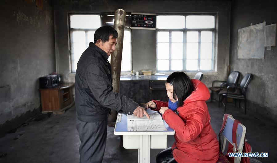 Hu Zhisheng tutors his student Sun Xiaofeng at Yantai primary school in Yantai Village of Lianhua Township in Tieling City, northeast China\'s Liaoning Province, Jan. 7, 2019. Located in a remote mountain village, most students of Yantai school had transferred to other places outside the mountain. Sun Xiaofeng, a third grade student, became the only student of the school in September last year taught by Hu Zhisheng, the only one faculty of Yantai primary school. (Xinhua/Yao Jianfeng)