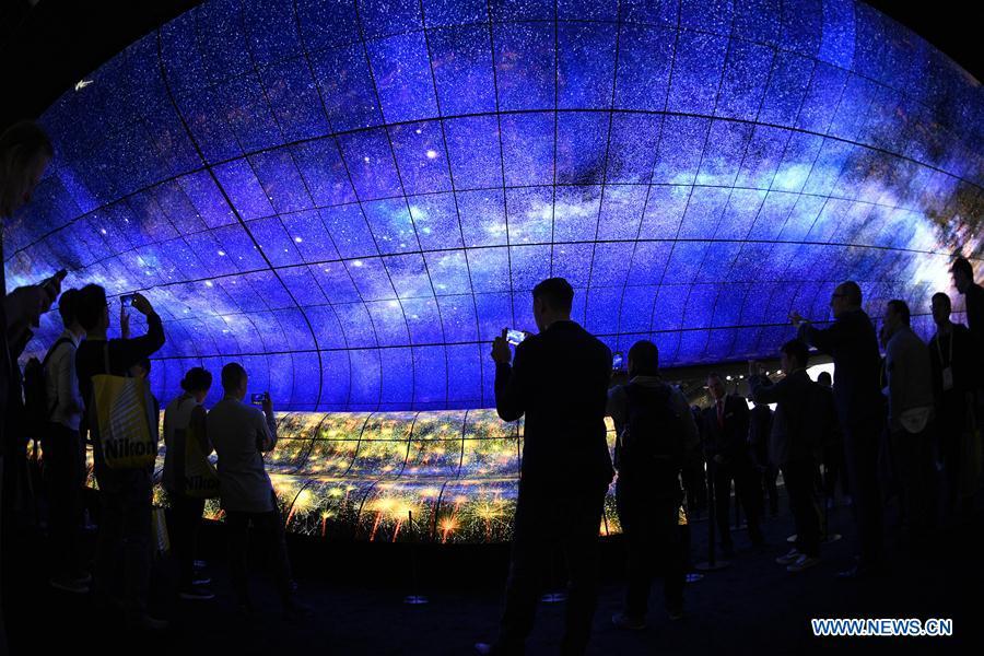 Visitors watch a giant curved display of LG during the Consumer Electronics Show (CES) in Las Vegas, the United States, on Jan. 8, 2019. 2019 CES highlights new displays from global companies, such as LG, Samsung and Sharp. CES, the world\'s largest trade show to present new products and technologies in the consumer electronics industry, runs till Friday, attracting about 4,500 exhibitors and 180,000 attendees in 2019. (Xinhua/Liu Jie)