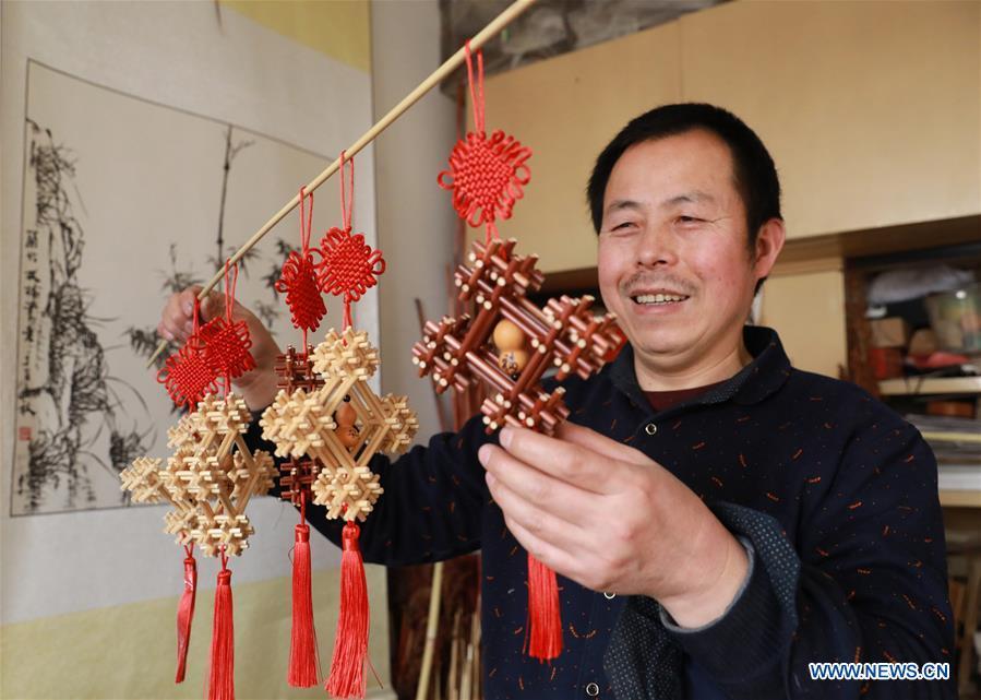 Craftsman Zhao Runsheng displays Chinese knots made of sorghum straws at a studio in Jingxing mining area of Shijiazhuang City, capital of north China\'s Hebei Province, Jan. 10, 2019. Sorghum straw handicrafts with various shapes in Jingxing Mining Area are a provincial intangible cultural heritage and a typical folk art in Hebei Province. (Xinhua/Liang Zidong)
