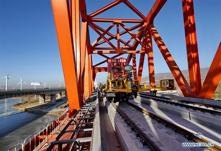 Workers lay the tracks for the Beijing-Zhangjiakou high-speed railway line at Guanting Reservoir grand bridge in north China\'s Hebei Province, on Jan. 13, 2019. Track laying work of the Beijing-Zhangjiakou high-speed railway line at Guanting Reservoir grand bridge was completed on Sunday. The 174-km-long railway, connecting China\'s capital Beijing and Zhangjiakou of north China\'s Hebei Province, is a major transportation project for the 2022 Winter Olympic Games. (Xinhua/Yang Shiyao)