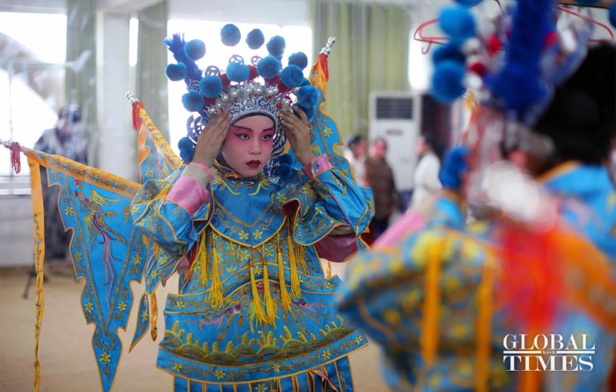A student adjusts her costume in front of a mirror.  (Photos: Yang Hui/GT)