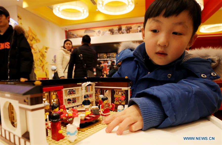 A child views toy bricks under the theme of new year\'s eve dinner to coincide with the Spring Festival at a store in east China\'s Shanghai, Jan. 14, 2019. (Xinhua/Fang Zhe)