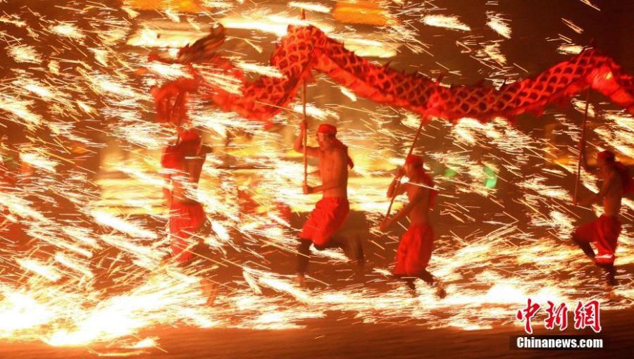 People perform a fire dragon dance in a shower of molten iron sparkling like fireworks to welcome the Spring Festival in Taierzhuang ancient town in Zaozhuang City, East China\'s Shandong Province, Jan. 13, 2019. The Spring Festival, or Chinese Lunar New Year, falls on Feb. 5 this year.  (Photo: China News Service/Yong Jun)