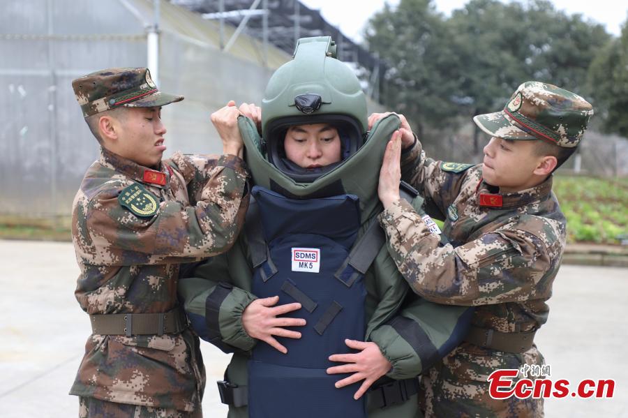 <?php echo strip_tags(addslashes(Deng Yutang puts on a pair of anti-explosion coveralls with the assistance of two soldiers during a training exercise in Guizhou Province, Jan. 14, 2019. Wearing anti-explosion coveralls weighing 30 kilograms each, members of the armed police unit specializing in explosive ordnance disposal conducted a drill on Monday, aided by a remotely-controlled bomb disposal device. (Photo: China News Service/Qu Honglun))) ?>