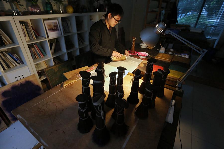 A woman is seen working on a traditional Yangliuqing woodblock printing.
