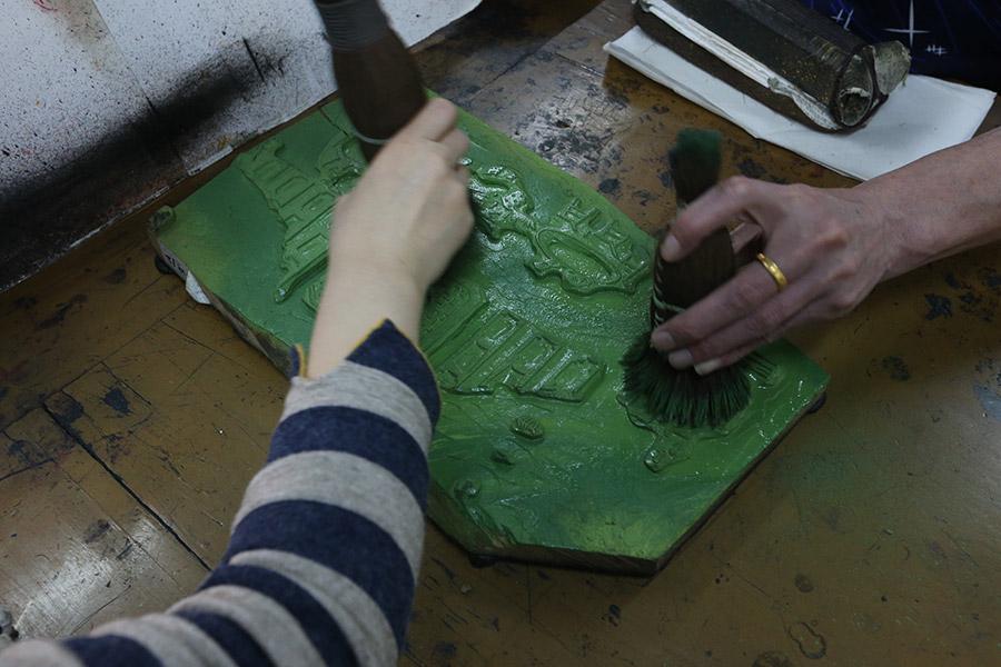 A woman is seen working on a traditional Yangliuqing woodblock printing. (Photo/chinadaily.com.cn)