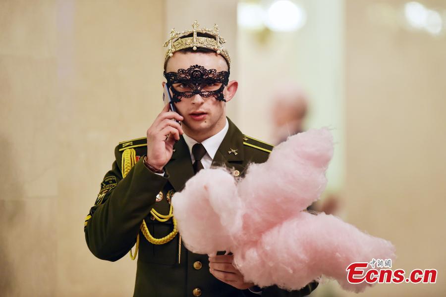 A Belarus\' military cadet holds cotton candy while speaking on his mobile phone during the Big New Year Ball at the Bolshoi Opera and Ballet Theatre in Minsk late on Jan. 13, 2019. (Photo/Agencies)