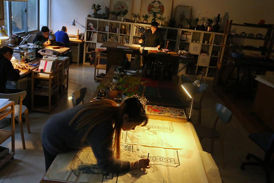 A woman is seen working on a traditional Yangliuqing woodblock printing.  (Photo/chinadaily.com.cn)