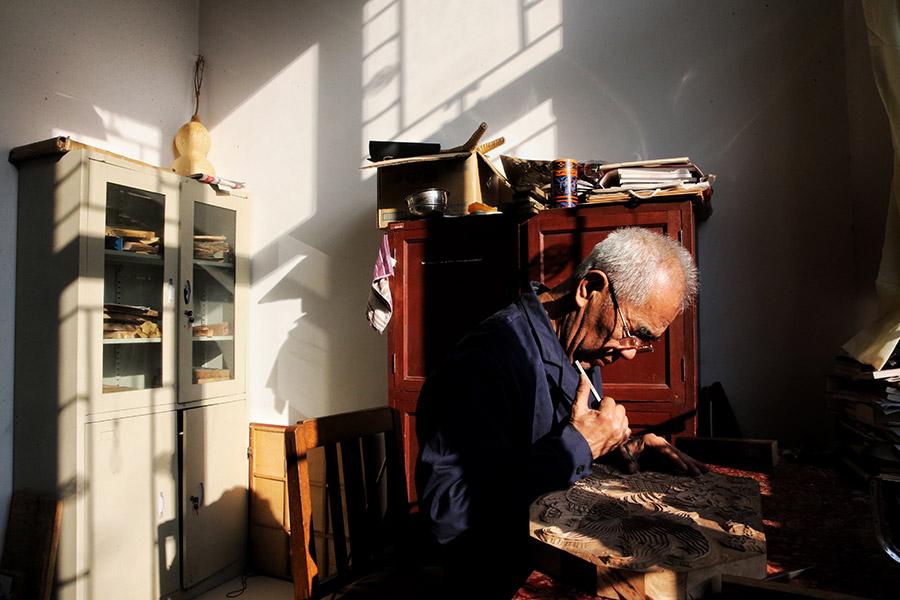 A man is seen working on a traditional Yangliuqing woodblock printing. (Photo/chinadaily.com.cn)